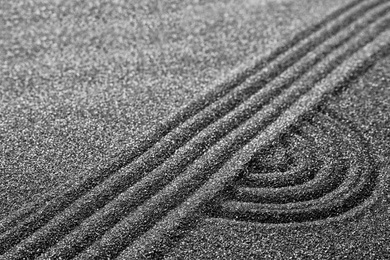 Pattern on decorative black sand, closeup. Zen and harmony