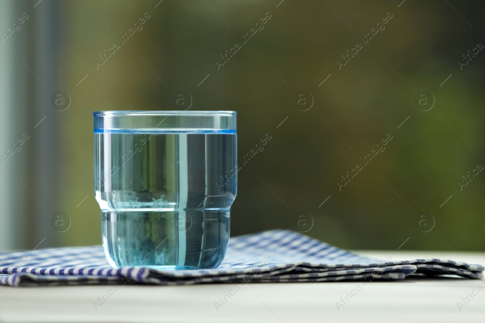 Photo of Glass of pure water on white table, space for text