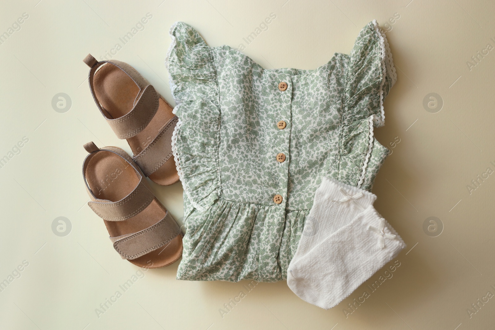 Photo of Stylish child clothes and shoes on beige background, flat lay