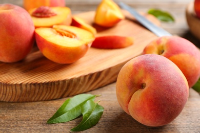 Photo of Fresh sweet peaches on wooden table, closeup