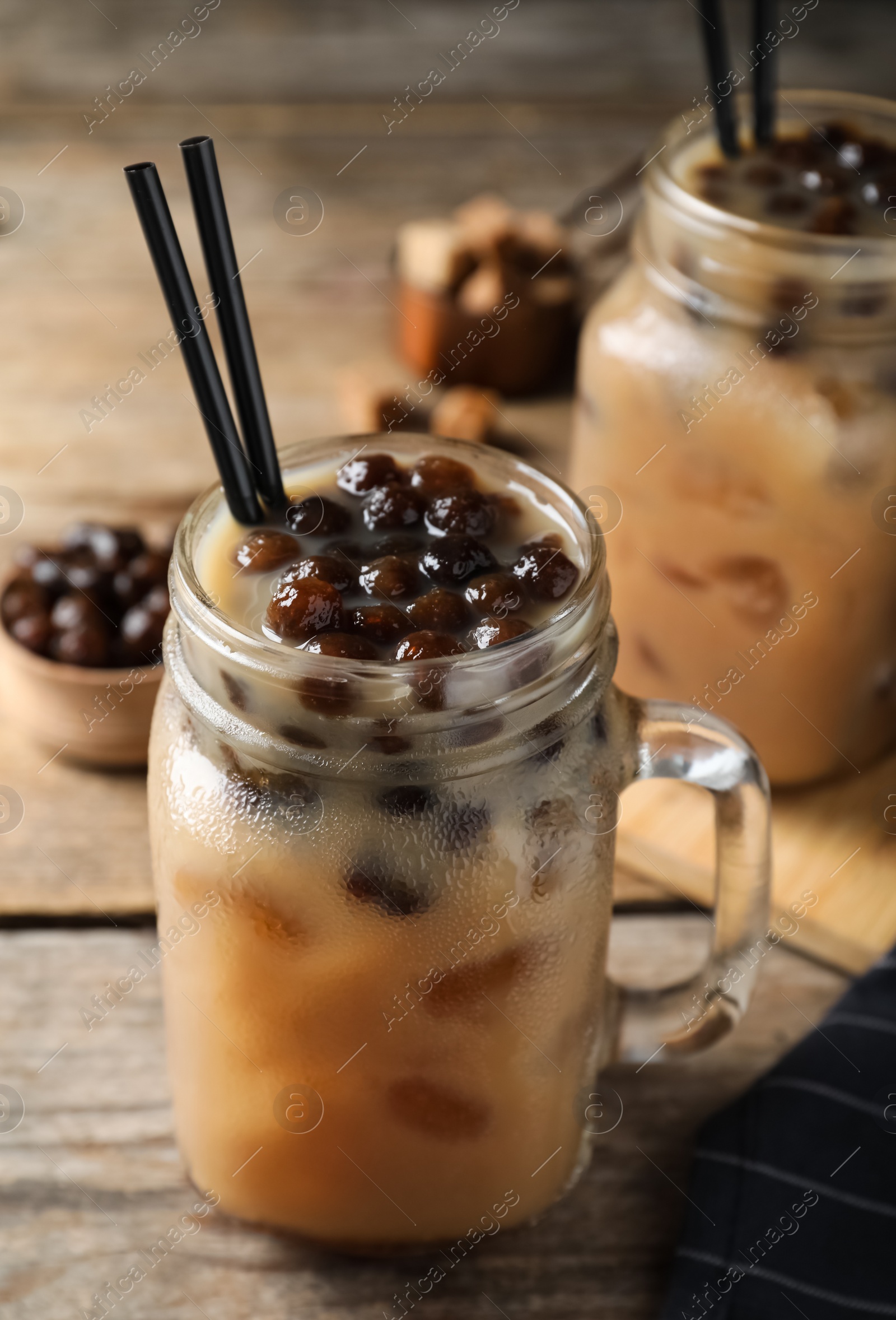 Photo of Tasty milk bubble tea on wooden table, closeup