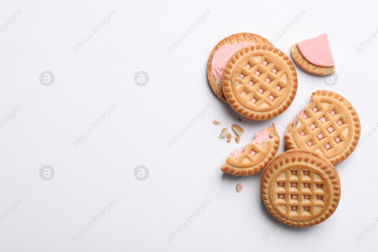 Photo of Tasty sandwich cookies with cream on white background, flat lay. Space for text