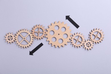 Photo of Business process organization and optimization. Scheme with wooden figures and arrows on lilac background, top view