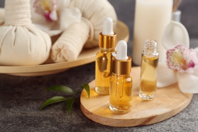 Beautiful spa composition with essential oils on grey table, closeup