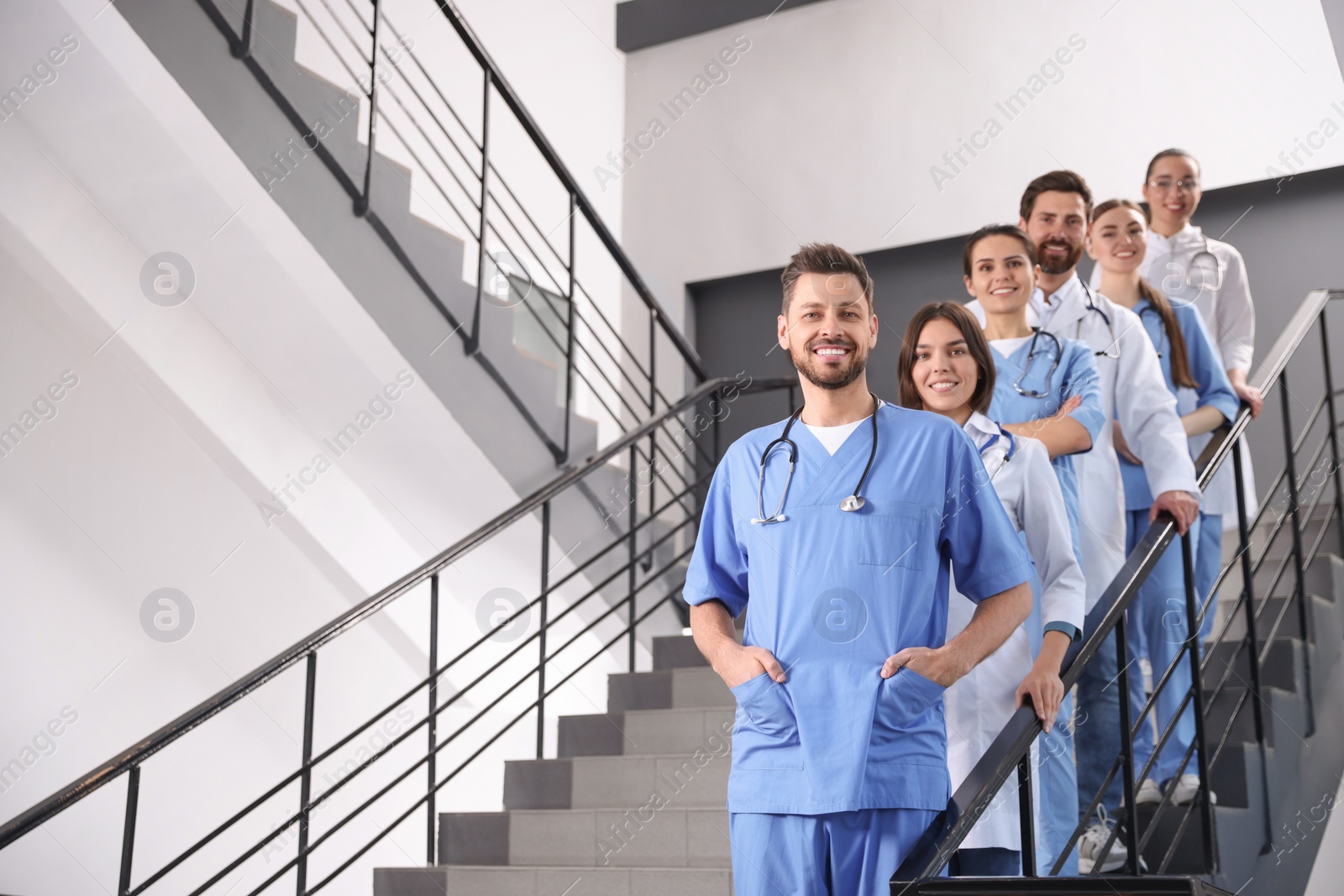 Photo of Team of professional doctors on staircase in clinic