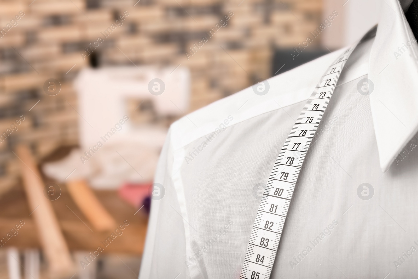 Photo of Mannequin with measuring tape in tailor studio, closeup