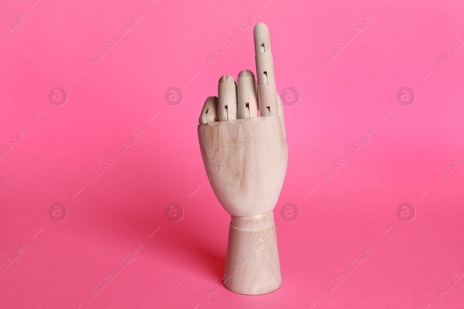 Photo of Wooden hand model on pink background. Mannequin part