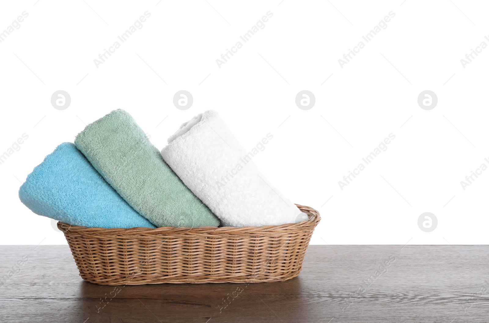 Photo of Fresh towels on wooden table against white background