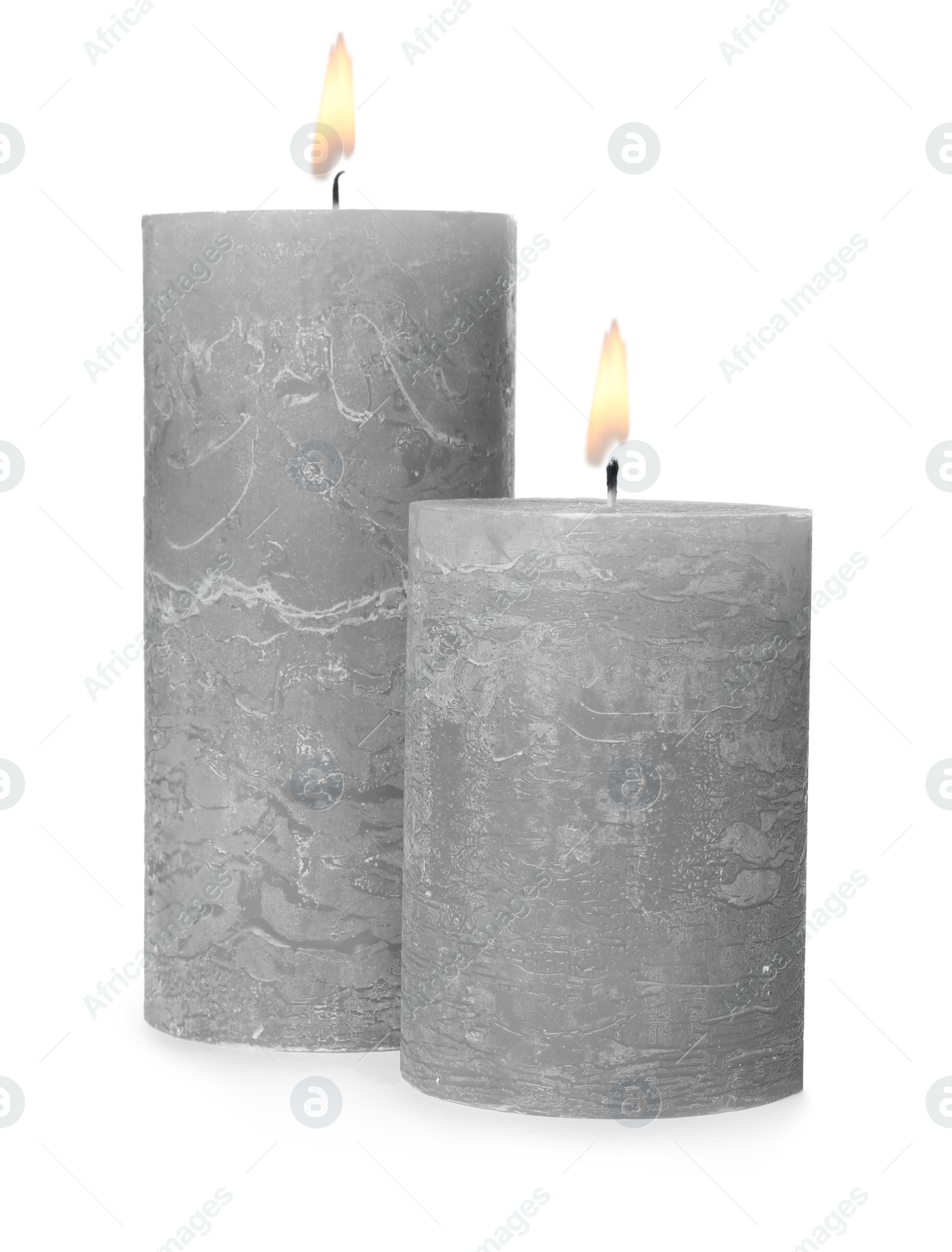 Photo of Two alight wax candles on white background