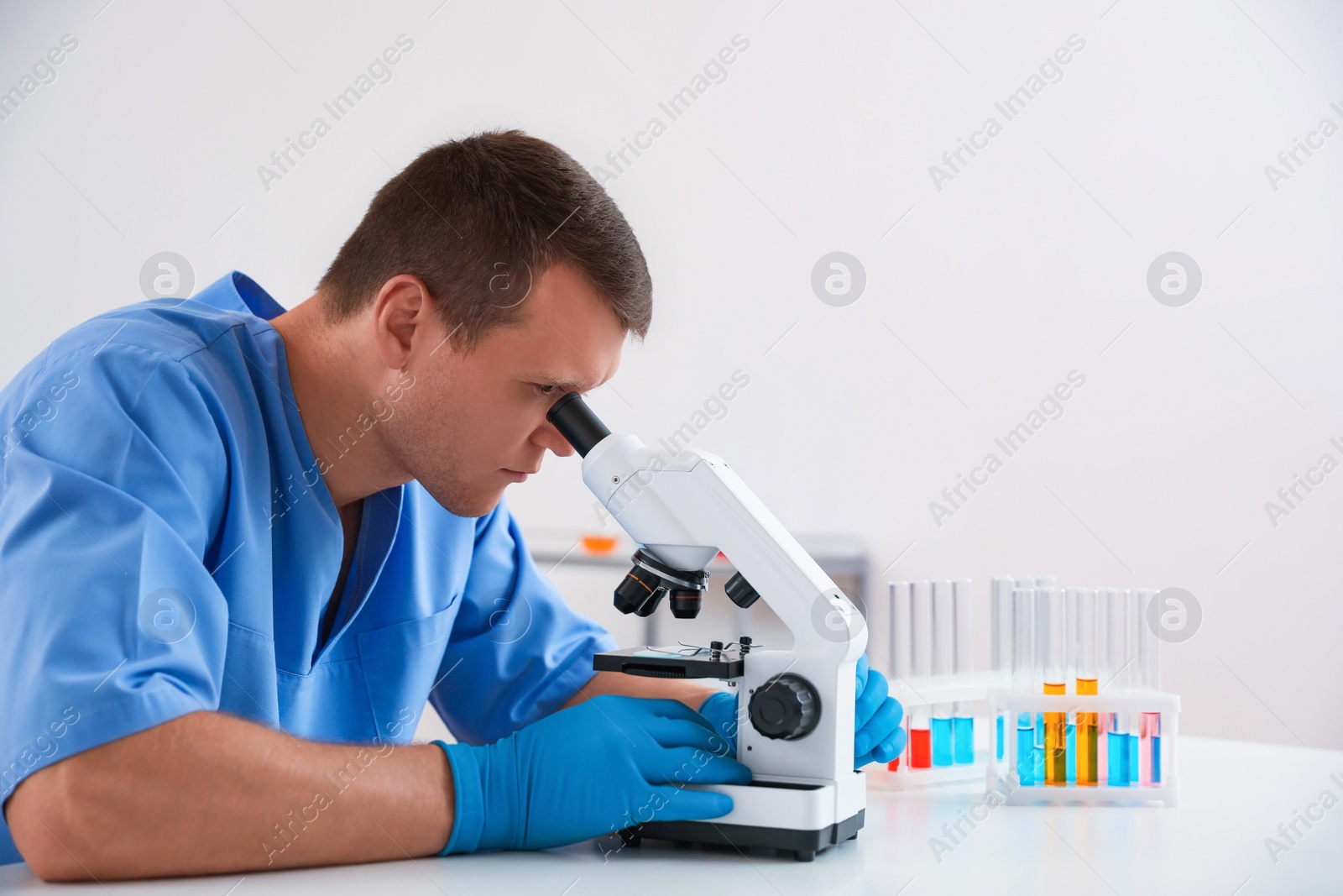 Photo of Scientist using modern microscope at table. Medical research