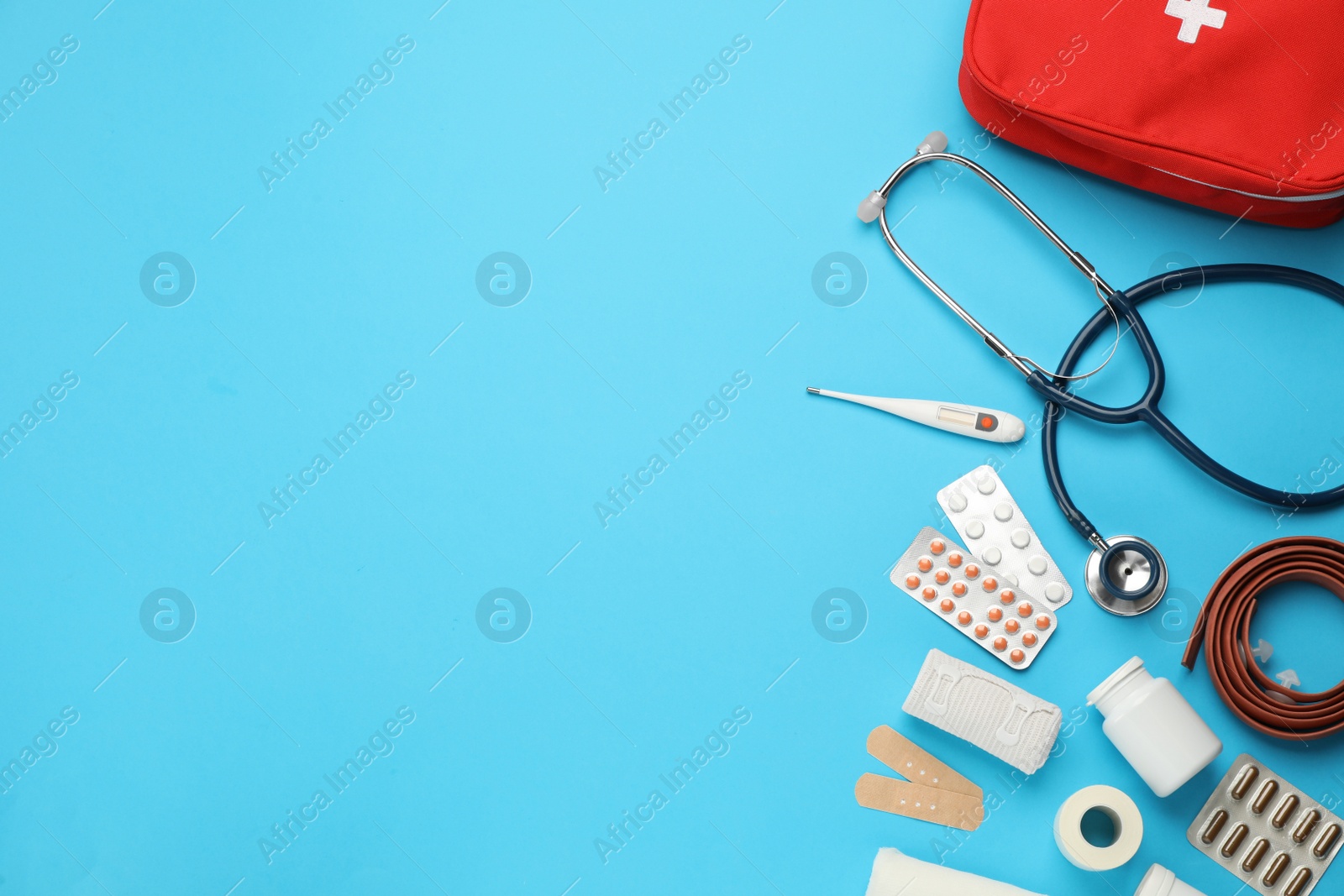 Photo of Flat lay composition with first aid kit on light blue background, space for text