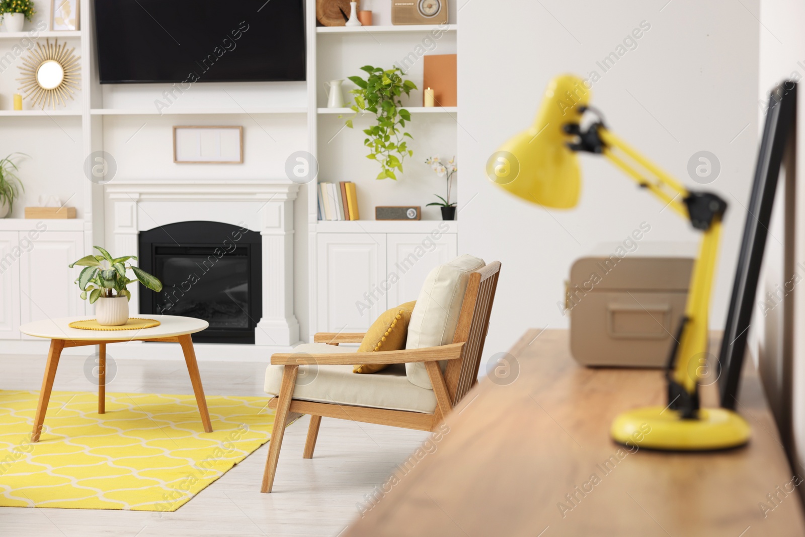 Photo of Spring interior. Yellow lamp on wooden table in stylish room