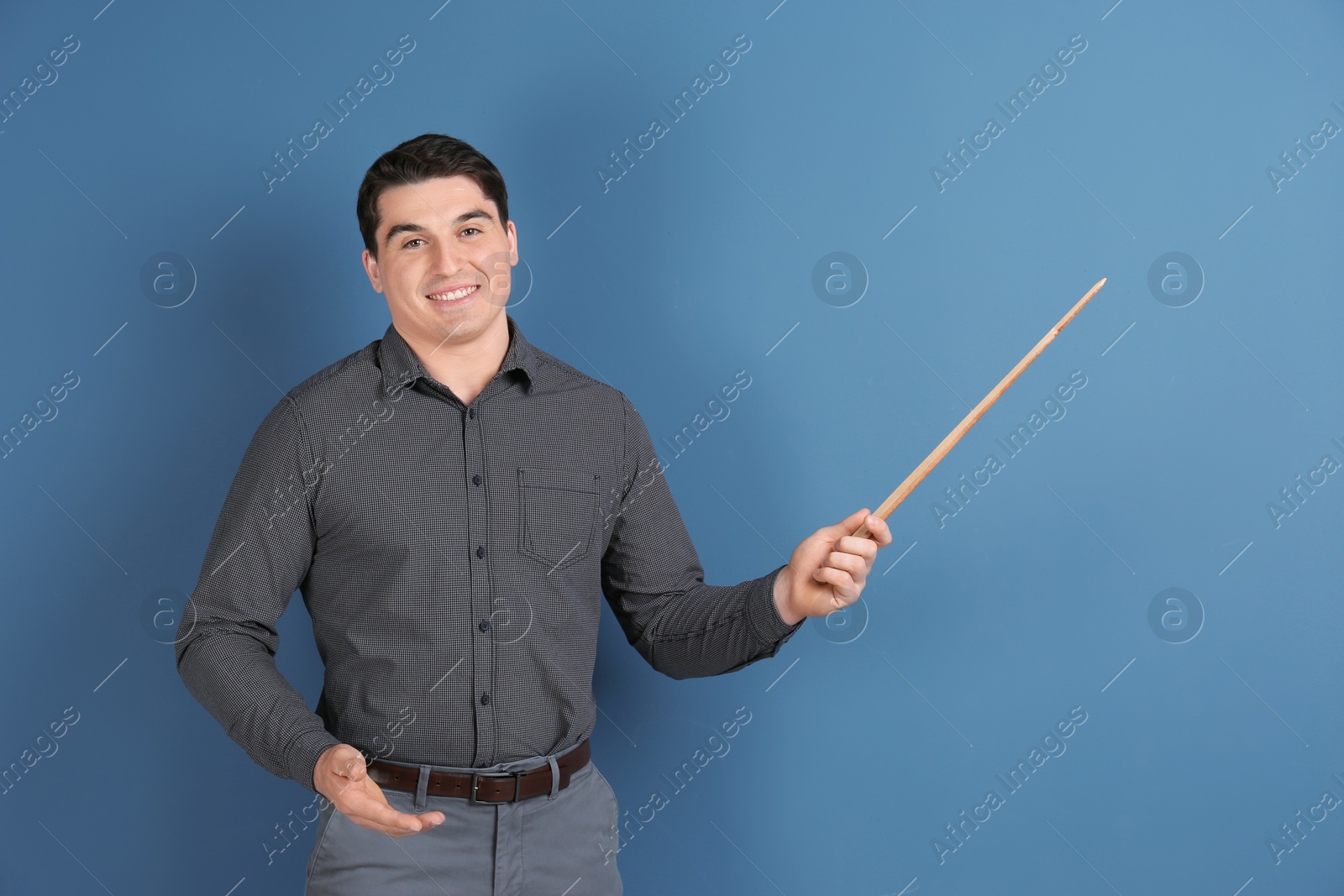 Photo of Portrait of male teacher with pointer on color background