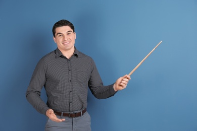 Portrait of male teacher with pointer on color background