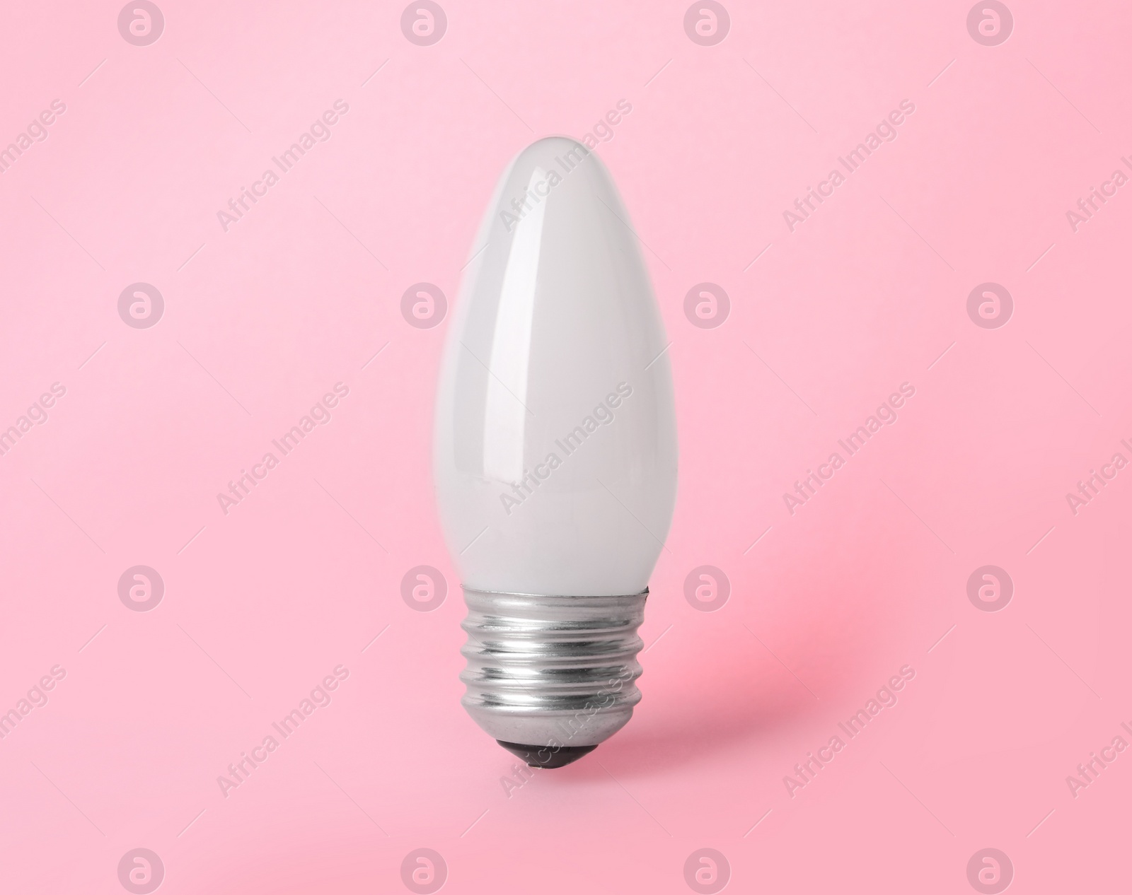 Photo of New modern lamp bulb on pink background