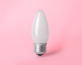 Photo of New modern lamp bulb on pink background