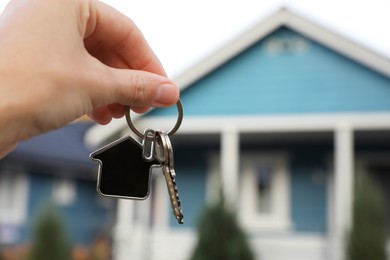 Photo of Woman holding house keys outdoors, closeup with space for text. Real estate agent
