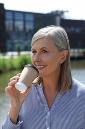 Photo of Portrait of beautiful happy senior woman drinking coffee outdoors
