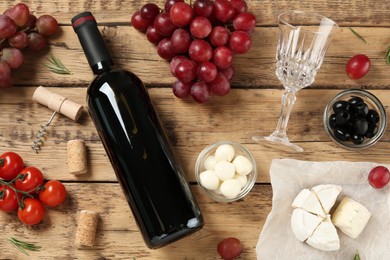 Photo of Flat lay composition with red wine and snacks on wooden table