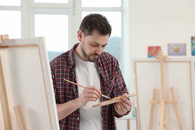 Handsome man painting in studio. Creative hobby