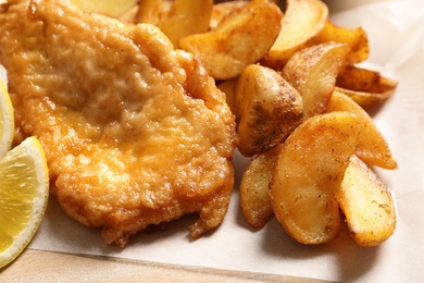 Photo of British traditional fish and potato chips, closeup