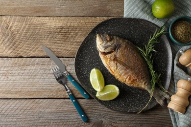 Delicious dorado fish served on wooden table, flat lay. Space for text