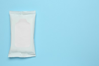 Wet wipes flow pack on light blue background, top view. Space for text