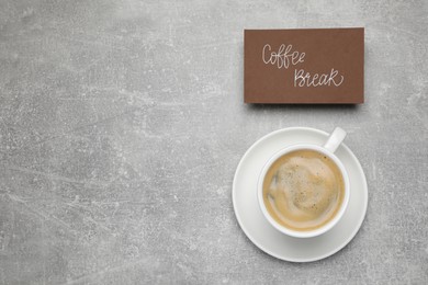 Photo of Card with phrase Coffee Break near cup of drink on light grey table, flat lay. Space for text