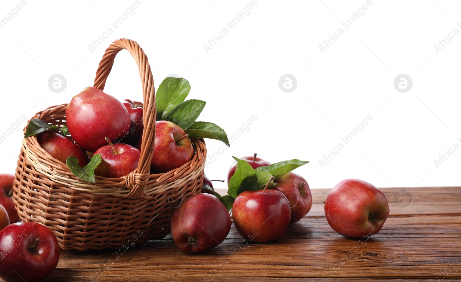 Photo of Ripe red apples and leaves on wooden table against white background