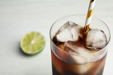 Photo of Refreshing soda drink with ice cubes and straw on white background, closeup. Space for text