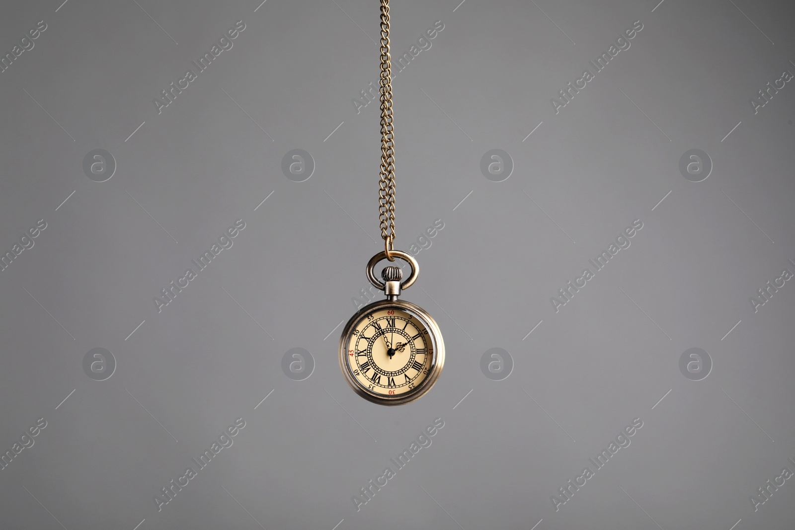Photo of Stylish pendulum on grey background. Hypnotherapy session