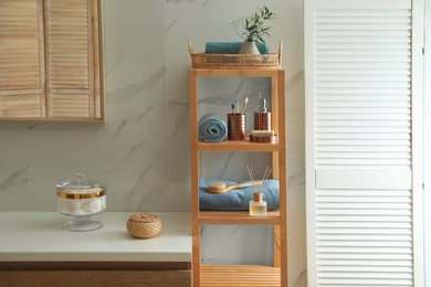 Photo of Shelving unit with toiletries in stylish bathroom interior 