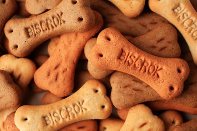 Photo of Bone shaped dog cookies as background, top view