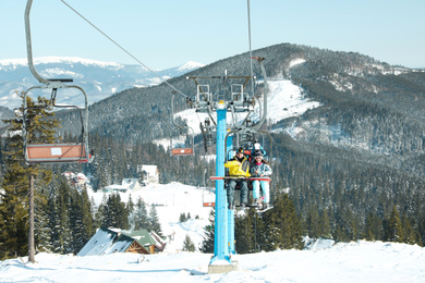 Photo of People using chairlift at mountain ski resort. Winter vacation