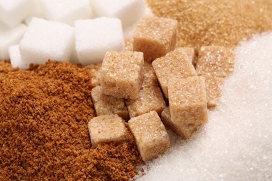 Photo of Different types of sugar as background, closeup
