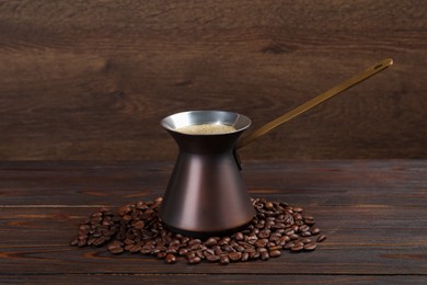 Photo of Hot turkish coffee pot and beans on wooden table