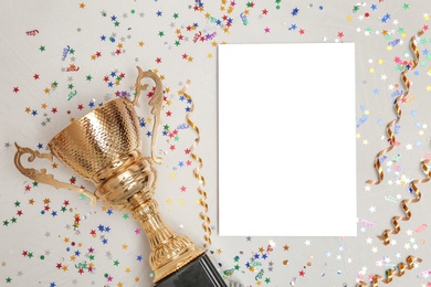 Photo of Trophy and blank paper on light background, top view with space for text. Victory concept