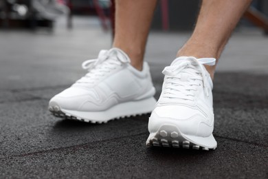 Photo of Man wearing pair of stylish sneakers outdoors, closeup