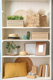 Photo of White shelving unit with plants and different decorative stuff