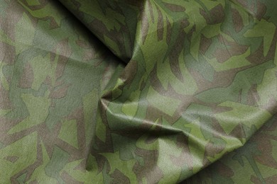Photo of Texture of crumpled camouflage fabric as background, top view