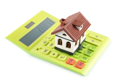 Photo of Calculator and house model on white background. Real estate agent concept