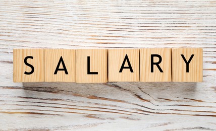 Image of Word Salary made with cubes on white wooden table, flat lay