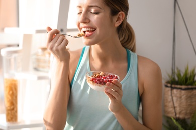 Photo of Young woman in fitness clothes having healthy breakfast at home