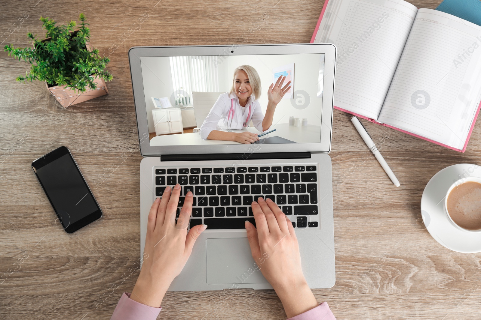 Image of Woman using laptop for online consultation with mature female doctor, top view 