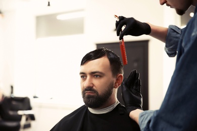 Photo of Professional barber working with client in hairdressing salon. Hipster fashion