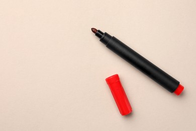 Photo of Bright red marker on beige background, flat lay. Space for text