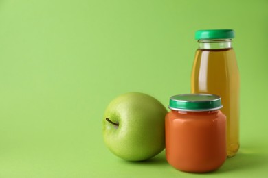 Photo of Healthy baby food, juice and apple on green background, space for text