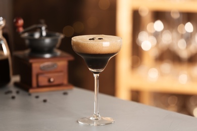 Photo of Glass of delicious Espresso Martini on bar counter. Alcohol cocktail