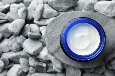 Photo of Jar of moisturizing cream on stones, top view. Space for text