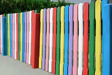 Photo of Colorful wooden fence on sunny day outdoors